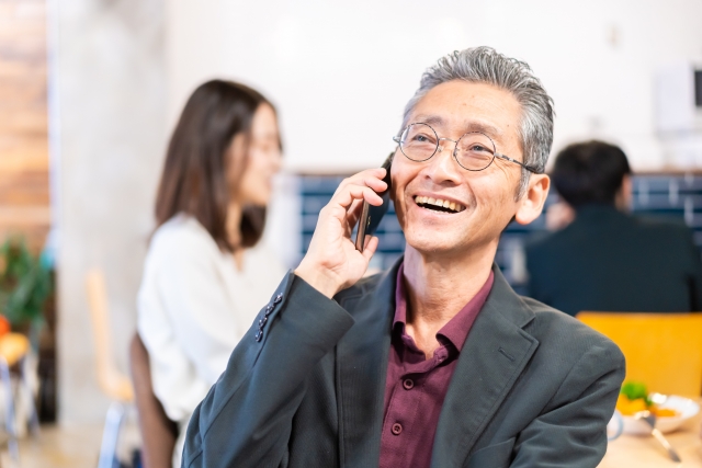 スマホで談笑する初老の男性