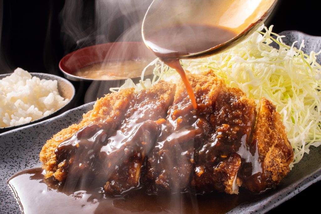 味噌カツにソースをかける