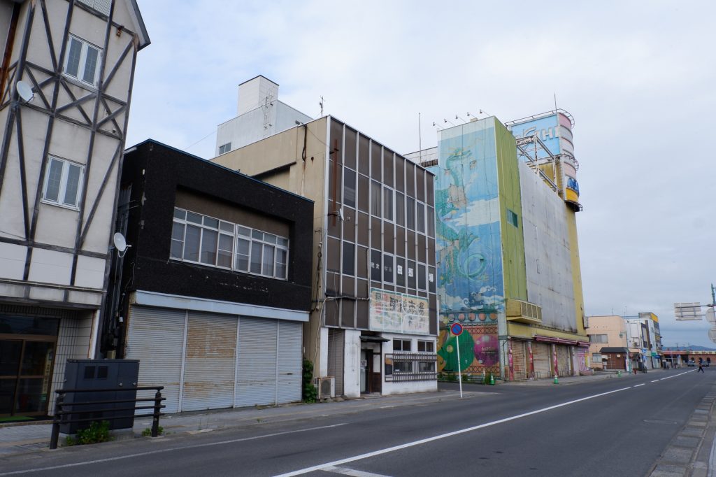 シャッターの閉まった店舗が並ぶ地方都市の商店街