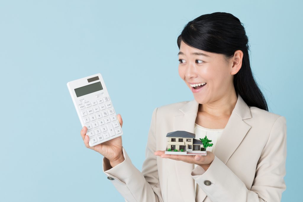 物件の模型と計算機を持った女性