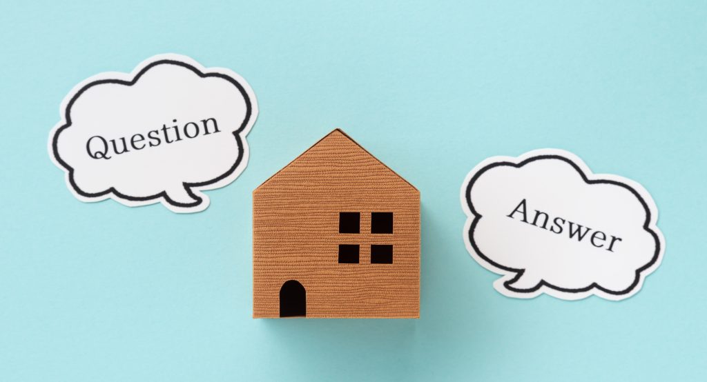 中古住宅の購入者が増えている理由や人気の背景を示す、家の模型とQuestion・Answer吹き出し