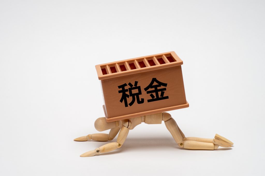 税金に潰されないように耐えるデッサン人形